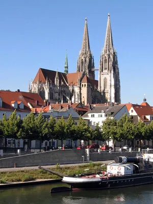 Regensburg Cathedral rising above the old town, with the Danube and a boat in front