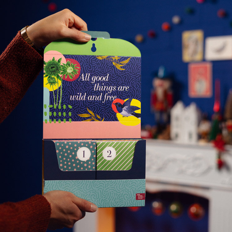 Opened seed advent calendar “Vegetables, Herbs & Flowers” with pockets 1 and 2, held in two hands