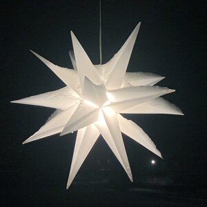 Glowing white Advent star in the dark